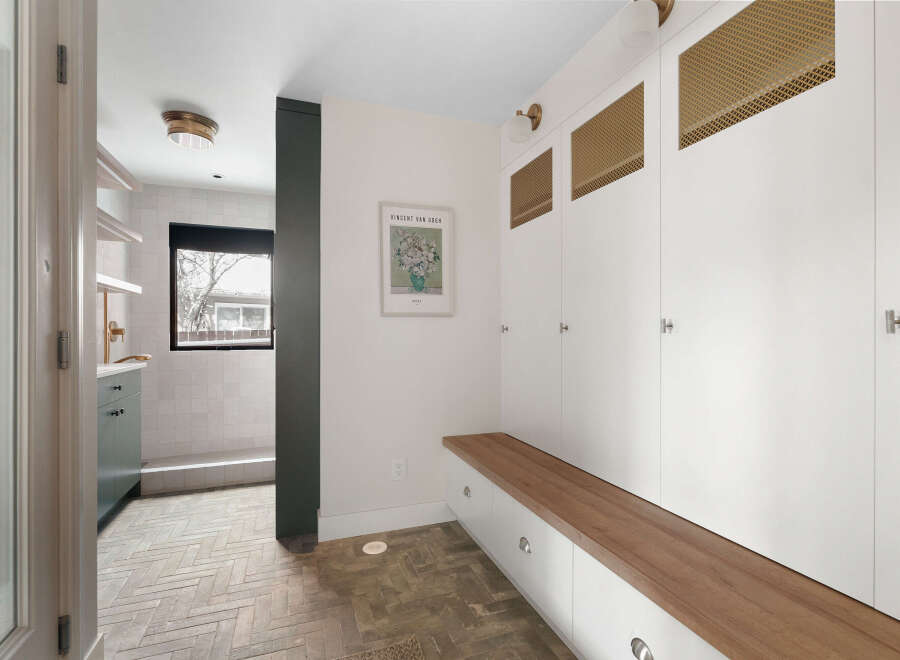 Step into this stylish entryway, featuring a custom built-in bench with ample storage and a warm wood top.