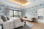 Step into luxury with this stunning bedroom featuring elegant blue and white wallpaper and a modern chandelier.