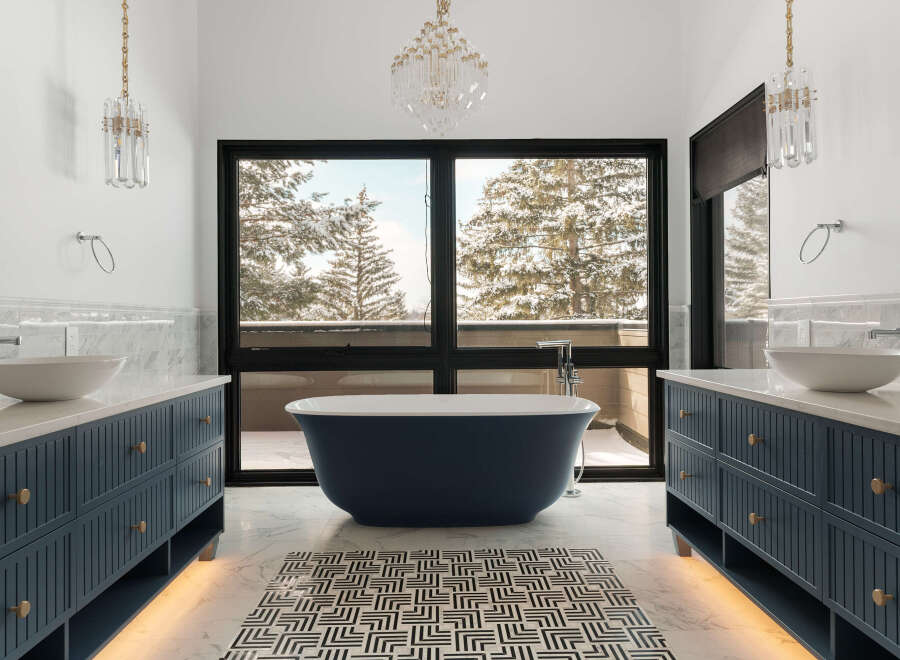 Indulge in the luxury of this stunning bathroom, featuring a deep blue soaking tub and elegant vanities.