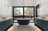 Indulge in the luxury of this stunning bathroom, featuring a deep blue soaking tub and elegant vanities.