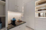 This stunning kitchen boasts a modern design with sleek white cabinetry and elegant gold hardware.