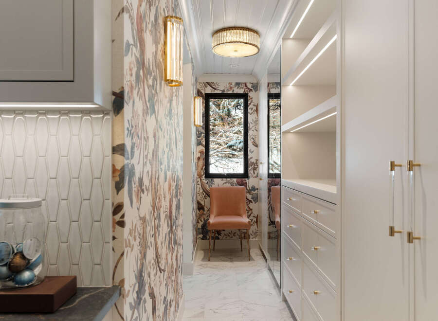 Step into luxury with this stunning walk-in closet, featuring elegant floral wallpaper and ample storage space.