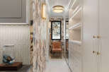 Step into luxury with this stunning walk-in closet, featuring elegant floral wallpaper and ample storage space.