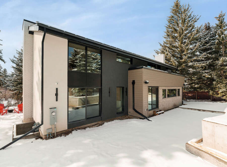 This stunning modern home boasts a sleek design with clean lines and expansive windows, perfect for enjoying the surrounding natural beauty.