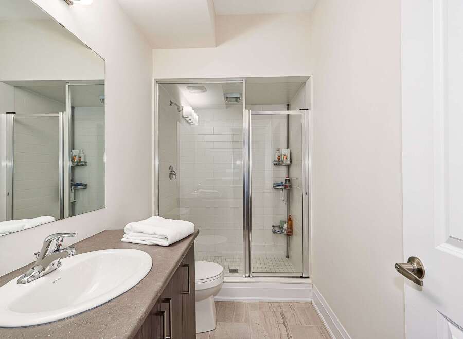 This modern bathroom features a sleek design with a glass-enclosed shower and a stylish vanity.