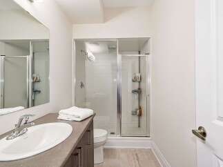 This modern bathroom features a sleek design with a glass-enclosed shower and a stylish vanity.