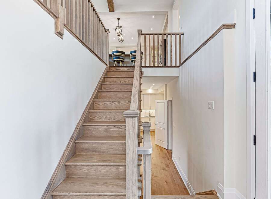 This stunning home features a grand staircase with beautiful wooden steps and railings, creating an inviting entrance.