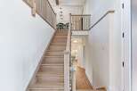 This stunning home features a grand staircase with beautiful wooden steps and railings, creating an inviting entrance.