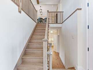 This stunning home features a grand staircase with beautiful wooden steps and railings, creating an inviting entrance.