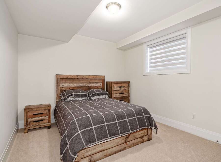 This cozy bedroom features a rustic wooden bed frame and headboard, creating a warm and inviting atmosphere.