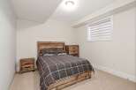 This cozy bedroom features a rustic wooden bed frame and headboard, creating a warm and inviting atmosphere.
