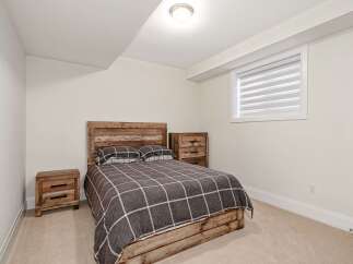This cozy bedroom features a rustic wooden bed frame and headboard, creating a warm and inviting atmosphere.