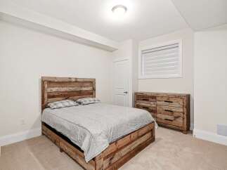 This bedroom showcases rustic charm with its wooden bed frame and dresser, creating a warm and inviting atmosphere.
