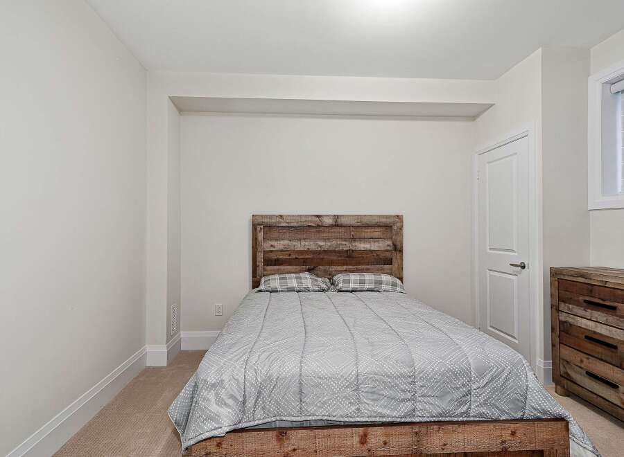 This cozy bedroom features a rustic wooden bed frame and headboard, creating a warm and inviting atmosphere.