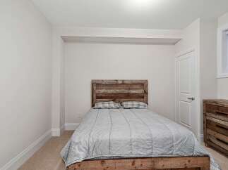 This cozy bedroom features a rustic wooden bed frame and headboard, creating a warm and inviting atmosphere.