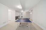 This spacious recreation room features a ping pong table, perfect for entertaining and family fun.