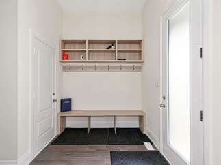 Step into this inviting entryway, featuring a stylish built-in bench and storage system, perfect for keeping your space organized.