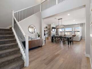 Step into luxury with this stunning property featuring a grand staircase and an open-concept living space.