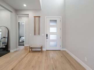 Step into this inviting entryway with beautiful hardwood floors and a modern design.
