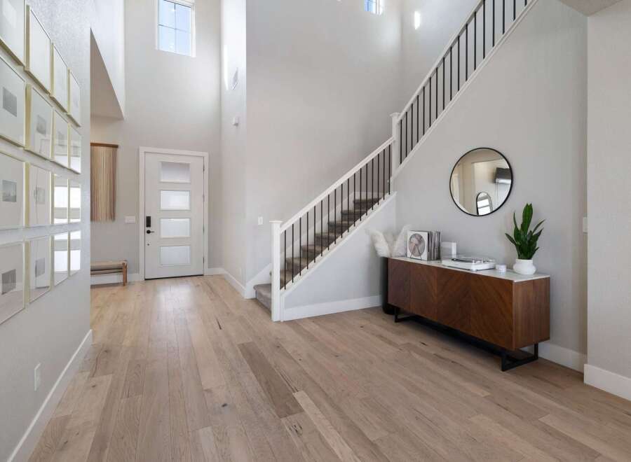 Step into luxury with this stunning entryway! Featuring a grand staircase, modern decor, and beautiful hardwood floors, this space is designed to impress.