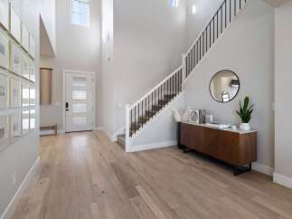 Step into luxury with this stunning entryway! Featuring a grand staircase, modern decor, and beautiful hardwood floors, this space is designed to impress.