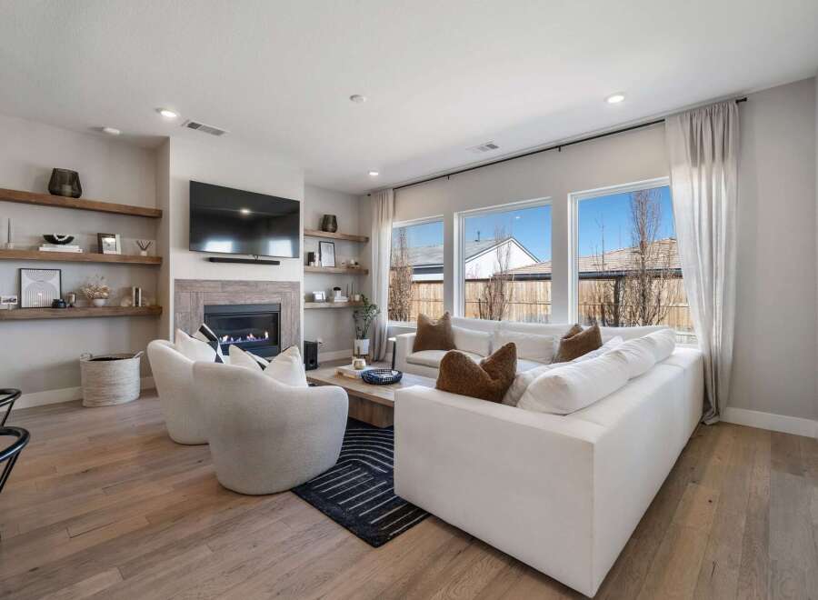 Step into luxury with this stunning living room, featuring a cozy fireplace and elegant floating shelves.