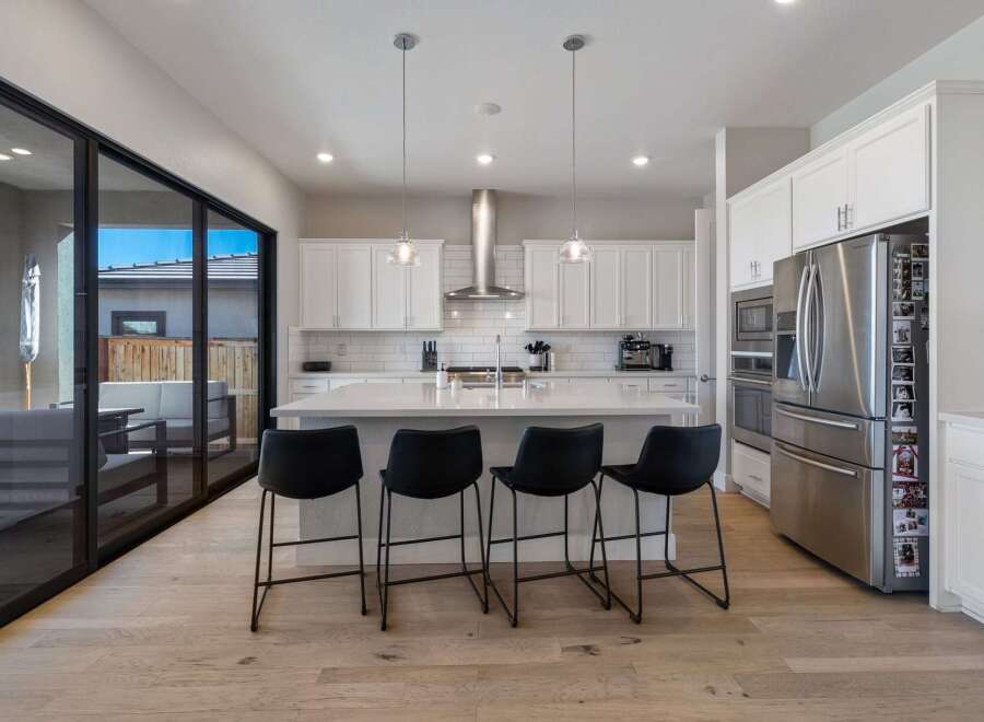 This stunning kitchen boasts a modern design with sleek white cabinetry and a spacious island, perfect for entertaining.
