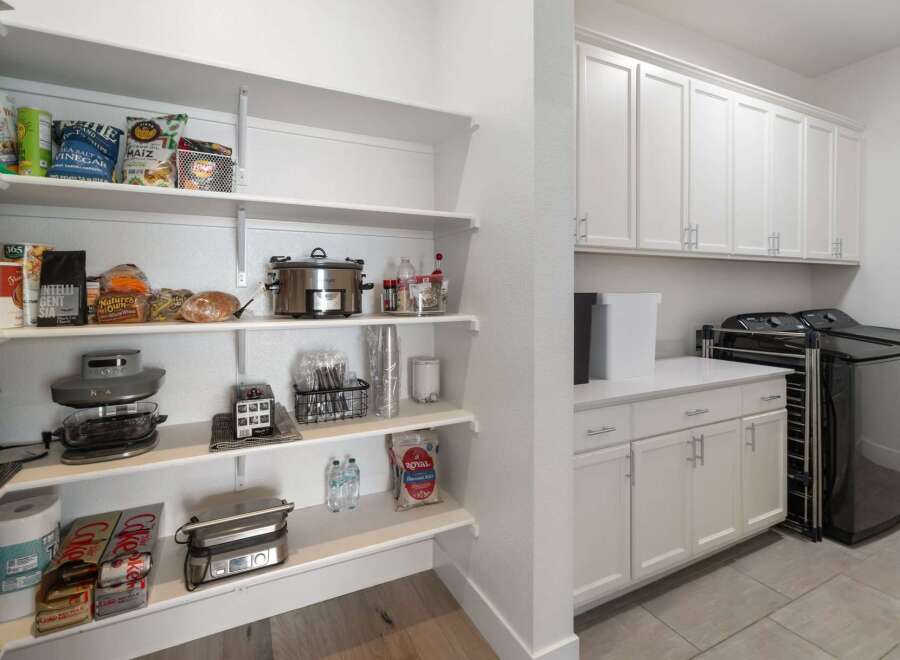 Discover the epitome of organized living with this meticulously designed pantry and laundry area.