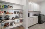 Discover the epitome of organized living with this meticulously designed pantry and laundry area.