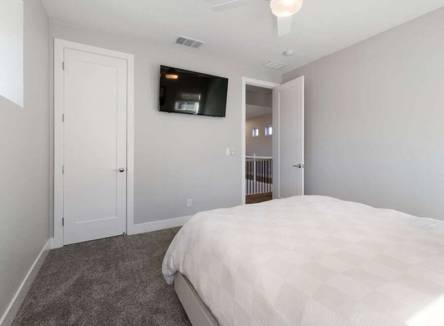 This modern bedroom offers a serene retreat with its neutral color palette and ample natural light.