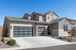 This stunning modern home boasts a sleek design with a spacious driveway and a beautifully landscaped front yard.