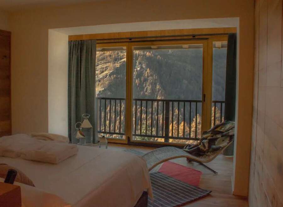 Experience breathtaking mountain views from this luxurious bedroom.