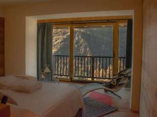 Experience breathtaking mountain views from this luxurious bedroom.