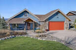 This stunning home boasts a beautiful exterior with a vibrant red garage door and a charming stone facade.