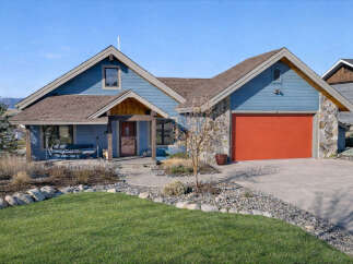 This stunning home boasts a beautiful exterior with a vibrant red garage door and a charming stone facade.