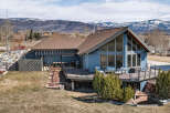This stunning property boasts a beautiful blue exterior and a spacious deck, perfect for enjoying the breathtaking mountain views.