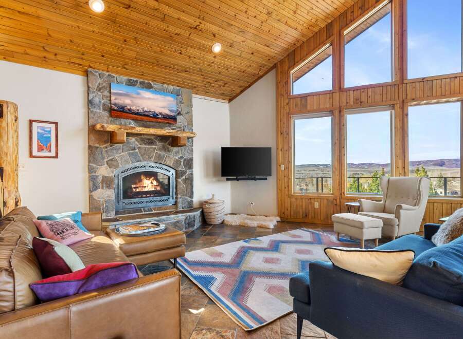 Experience the warmth and charm of this stunning living room, featuring a cozy fireplace and a rustic stone facade.