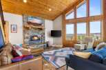 Experience the warmth and charm of this stunning living room, featuring a cozy fireplace and a rustic stone facade.