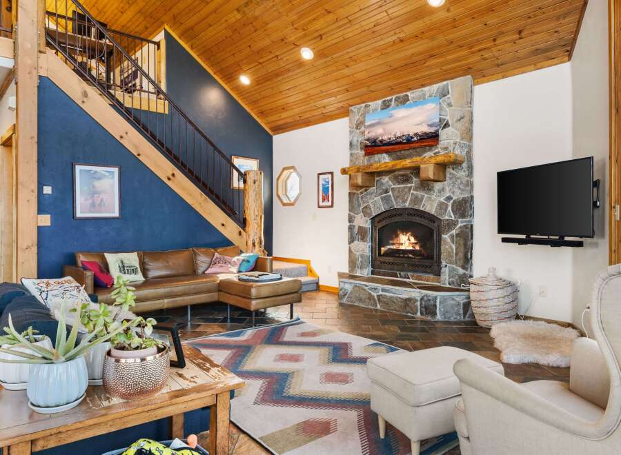 This stunning property boasts a cozy living room with a stone fireplace, perfect for relaxing evenings.