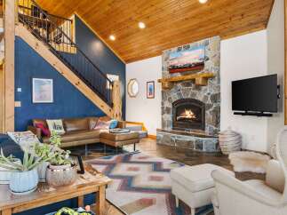 This stunning property boasts a cozy living room with a stone fireplace, perfect for relaxing evenings.