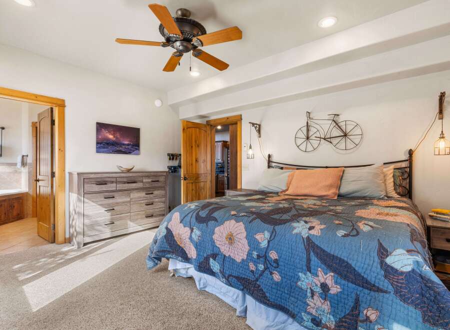 Step into this inviting bedroom, featuring a cozy bed adorned with a beautiful floral quilt.