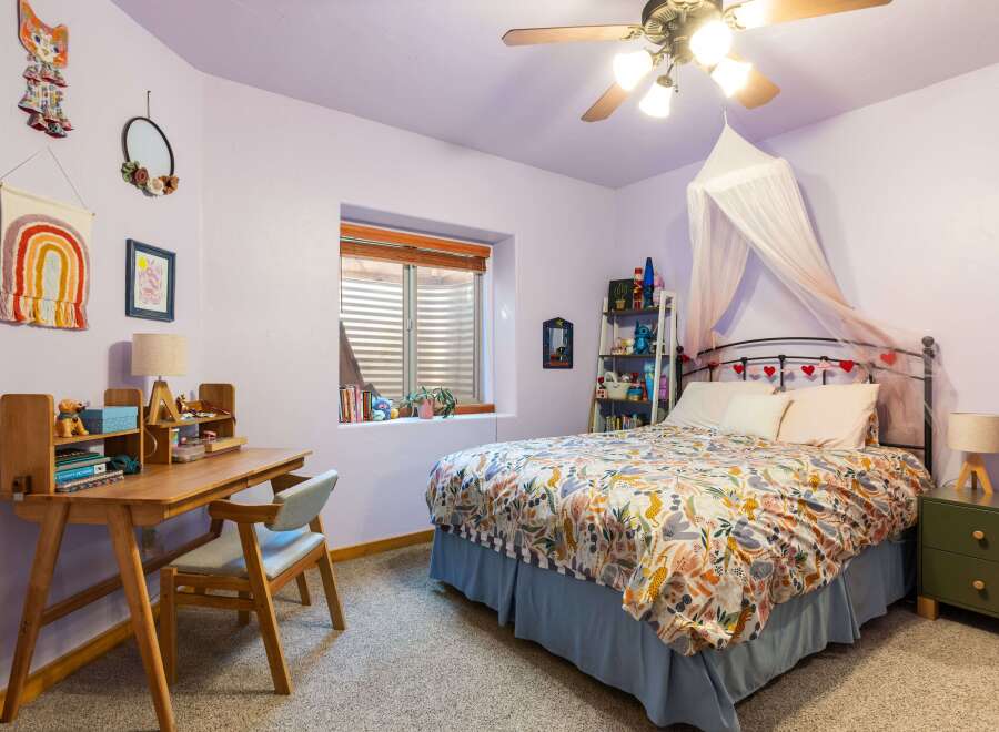 This charming bedroom features a cozy desk area perfect for work or study.