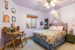 This charming bedroom features a cozy desk area perfect for work or study.