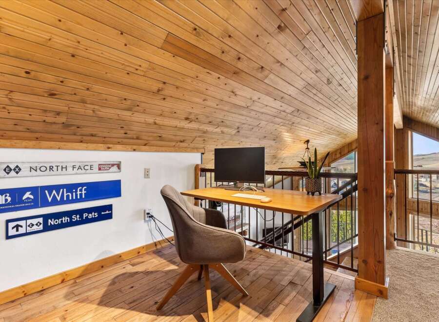 This stunning loft space features a cozy home office with a modern desk and chair, perfect for remote work or creative projects.