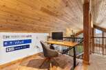 This stunning loft space features a cozy home office with a modern desk and chair, perfect for remote work or creative projects.