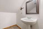 Discover the charm of this unique bathroom! Featuring a stylish pedestal sink and a decorative mirror, this space offers both functionality and aesthetic appeal.