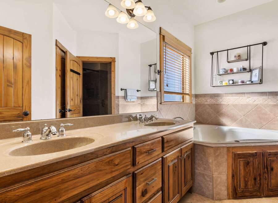 This luxurious bathroom boasts a stunning design with a double vanity featuring elegant fixtures and a spacious countertop.