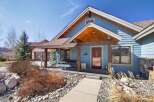 Charming blue house with a welcoming porch and a touch of rustic elegance.