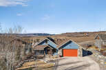 This stunning property boasts a beautiful exterior with a vibrant orange garage door, complemented by a stone facade.