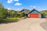 Discover this stunning blue home featuring a vibrant red garage door and charming stone accents.